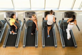 Photo: Four people walking on treadmills